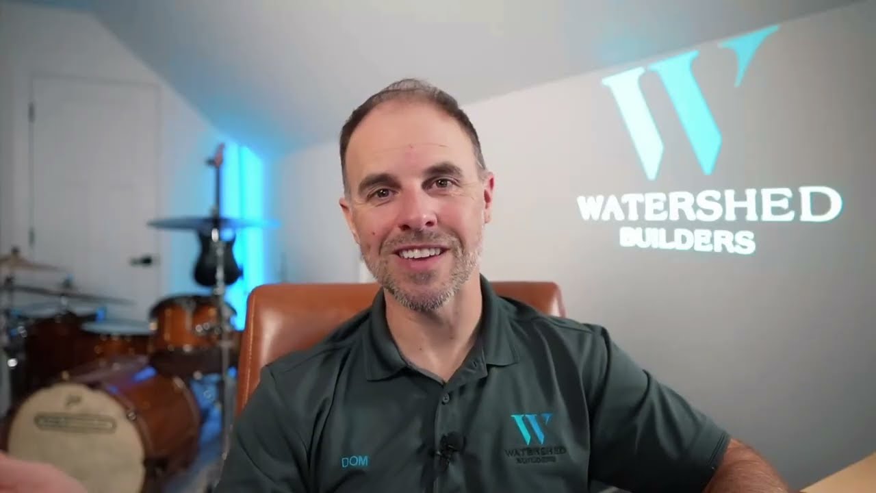 Dom Thompson, founder of Watershed Builders, speaking to camera in a branded Watershed polo